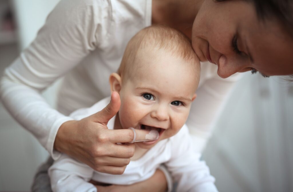 Mother gently massaging baby's gums.